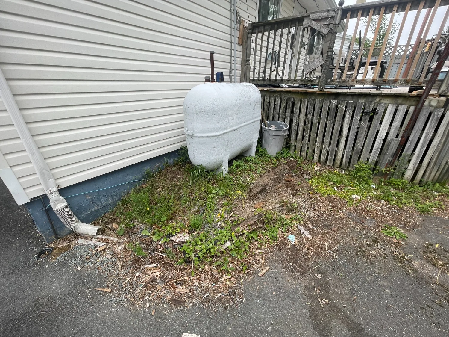 Before: unfinished ground around outdoor oil tank